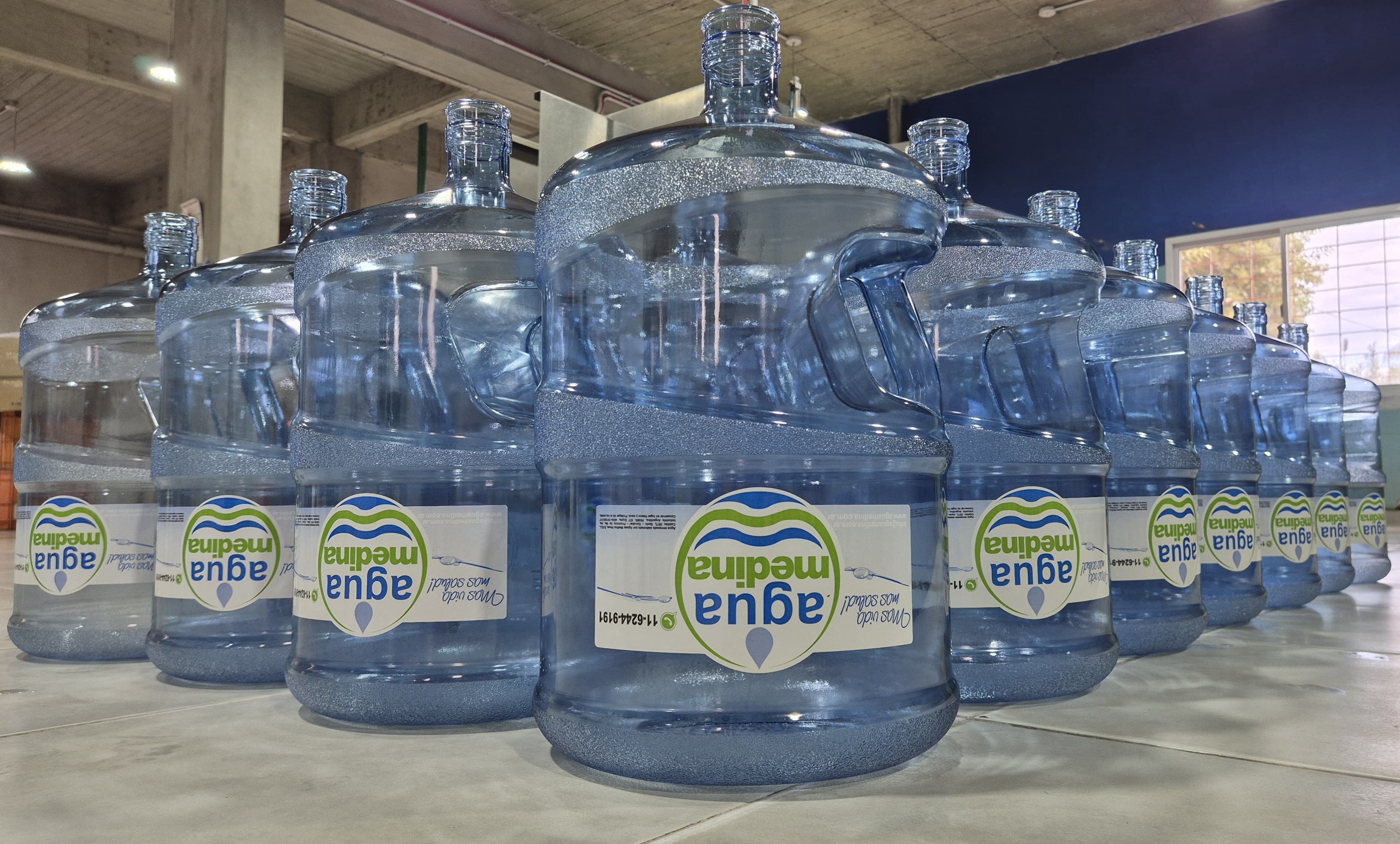 Planta embotelladora AquaPure moderna con trabajadores en uniforme blanco